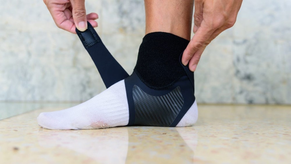 a person putting an ankle brace on their ankle over a sock