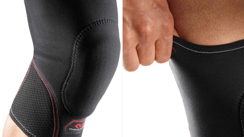 A person wearing black wrap-around knee pads with red detailing.